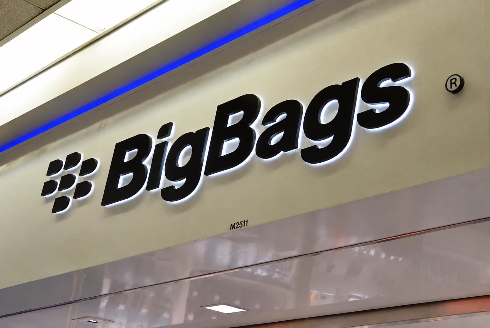 An illuminated BigBags storefront sign.